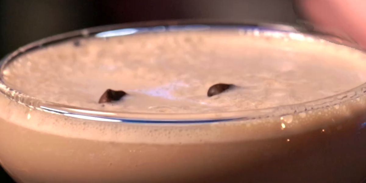 Close-up of a thick espresso martini foam with coffee beans