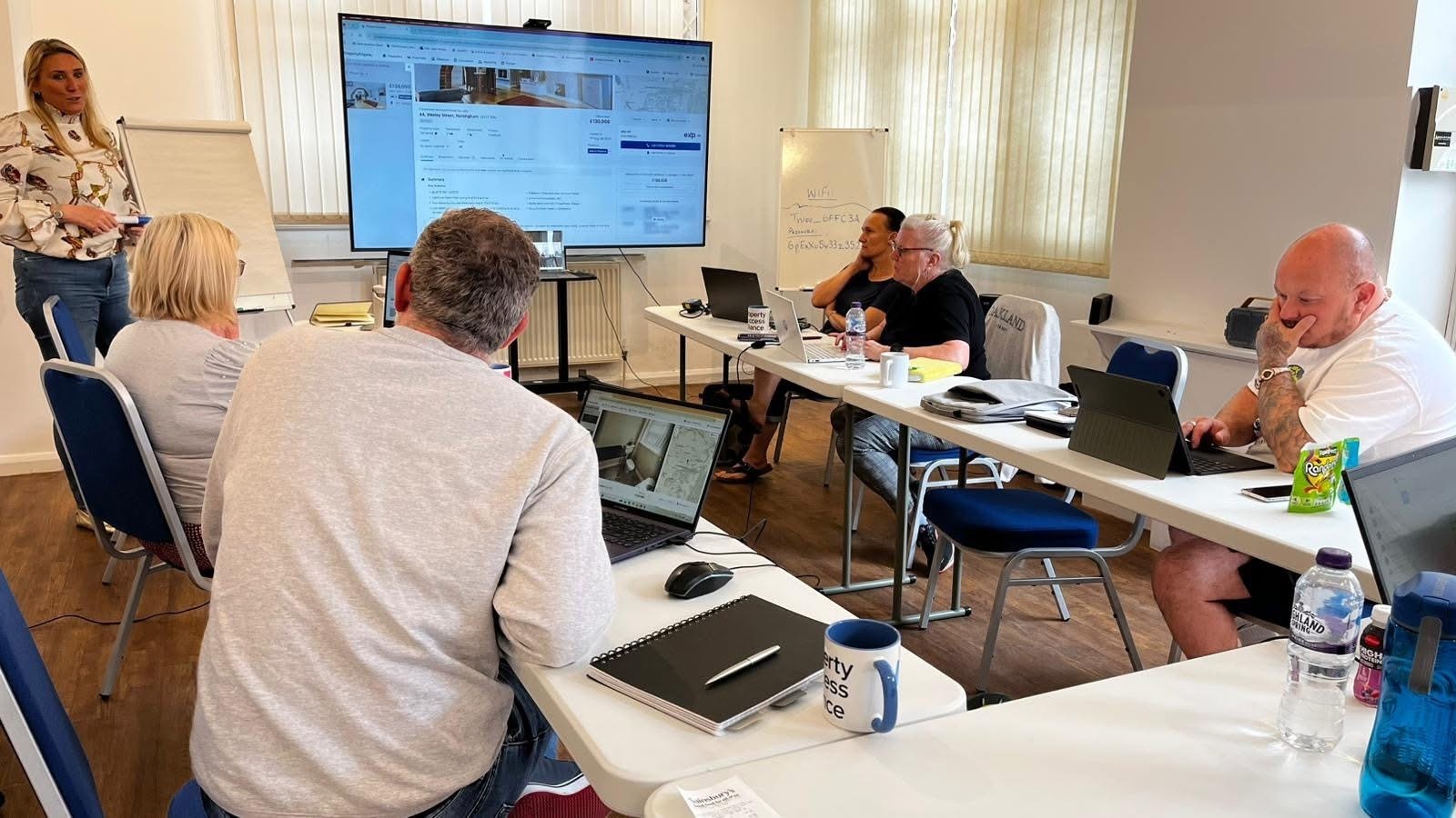 Delegates assessing property listings with laptops