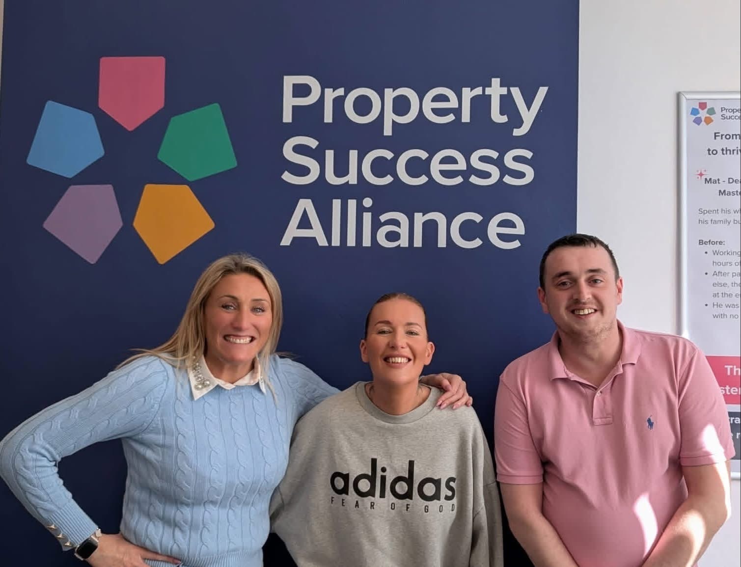Three people by the Property Success Alliance wall
