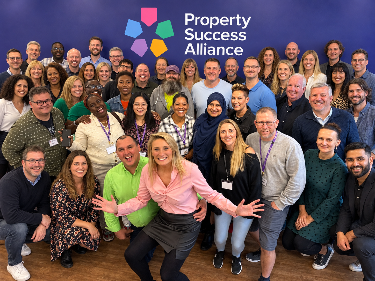 Edited Property Success Alliance group portrait with additional AI-generated attendees and an extended branded backdrop