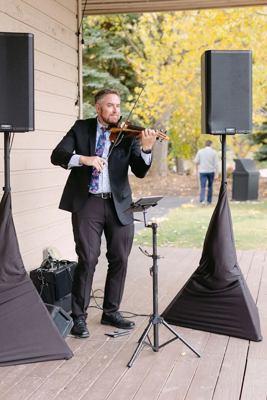 Wedding violinist Jared Judge playing on a covered deck at a wedding in EagleVail, near Vail, Colorado, with his own speakers