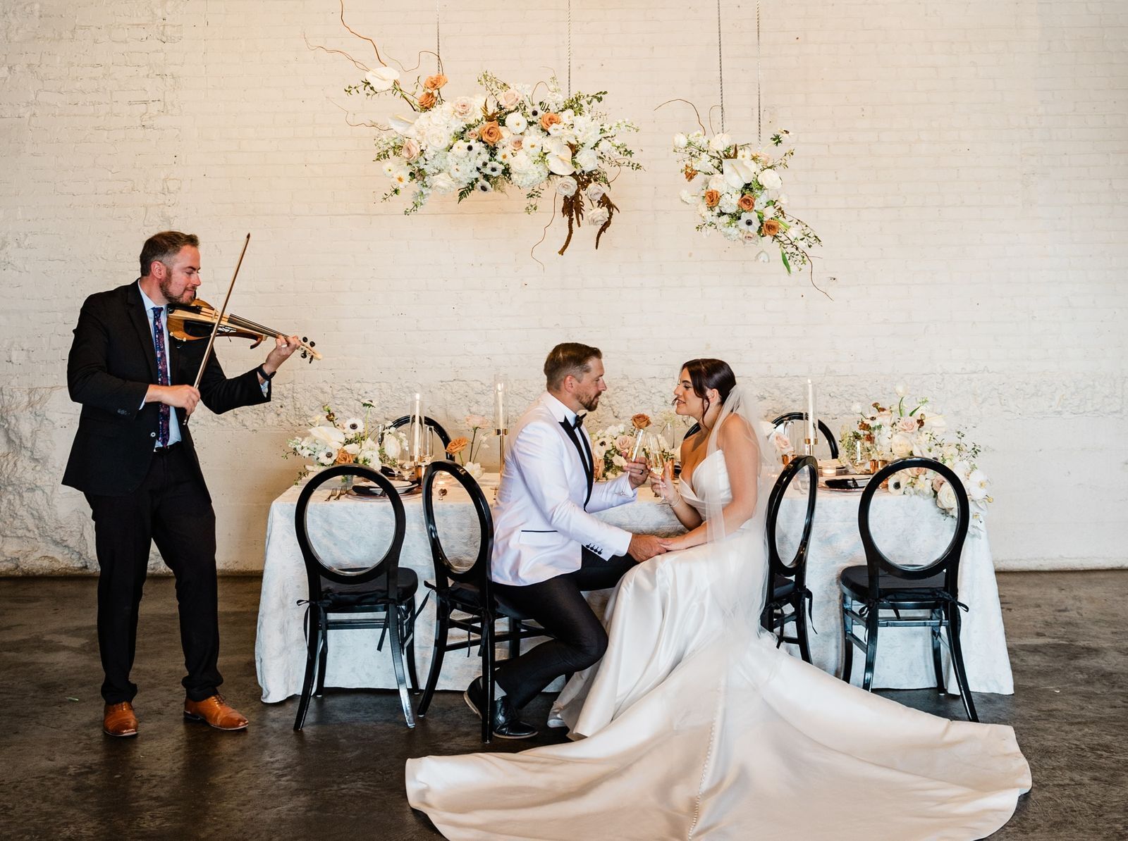 Denver wedding violinist Jared Judge playing electric violin beside a bride and groom at their sweetheart table