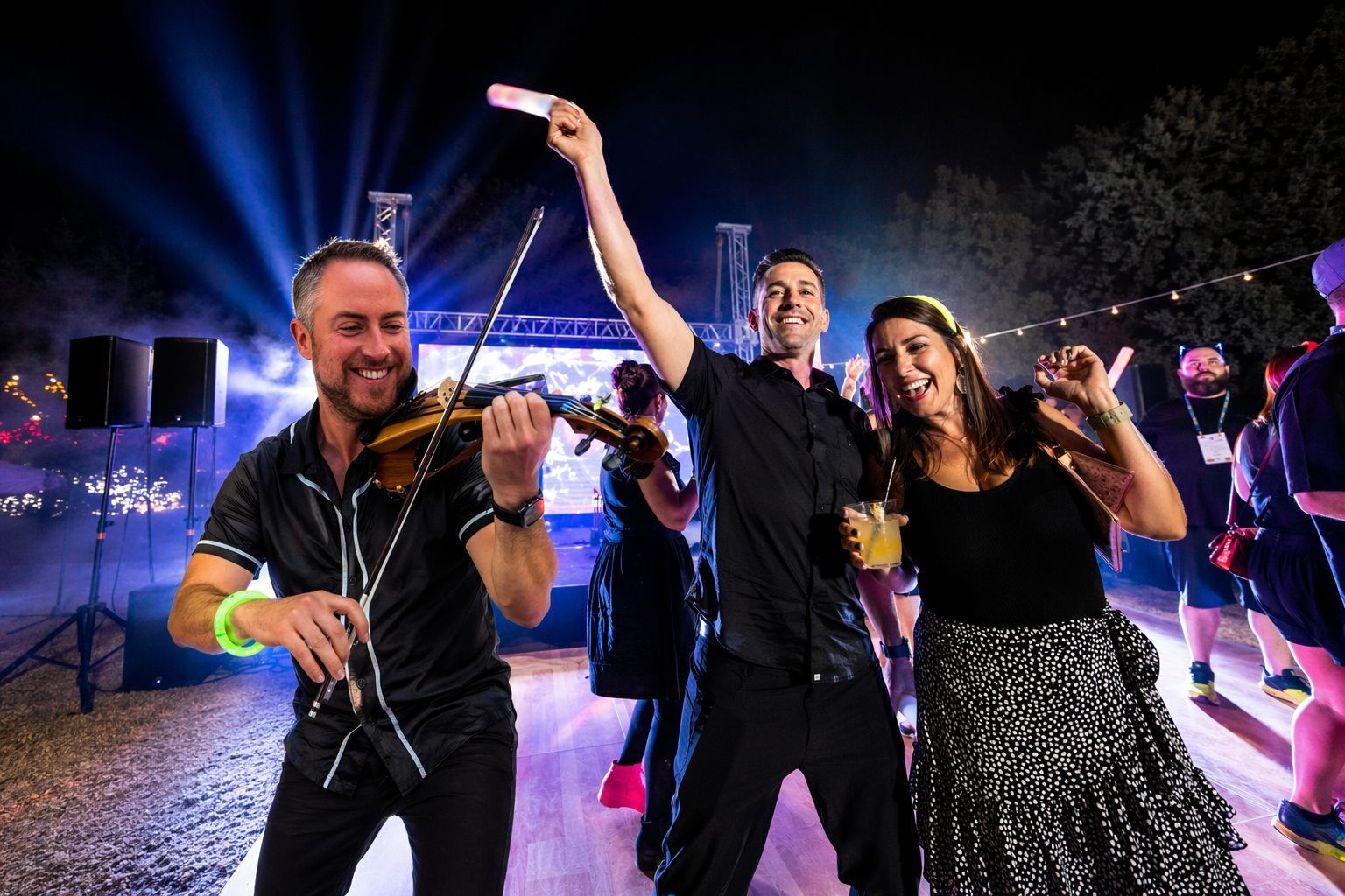 Electric violinist Jared Judge playing on the dance floor as guests dance and cheer